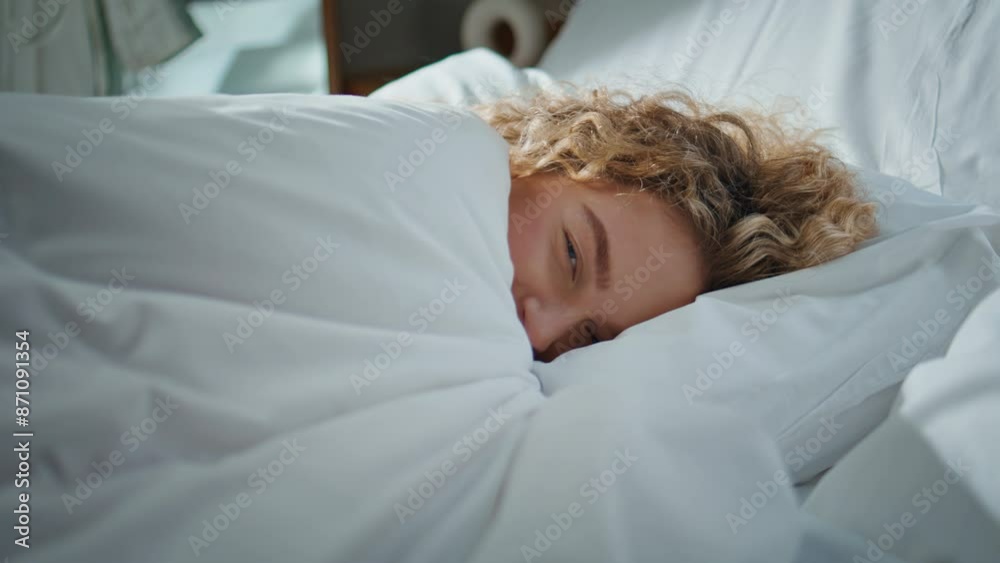 Morning woman resting bedroom in sunlight. Closeup curly girl peeking blanket Morning woman resting bedroom in sunlight. Closeup curly girl peeking blanket