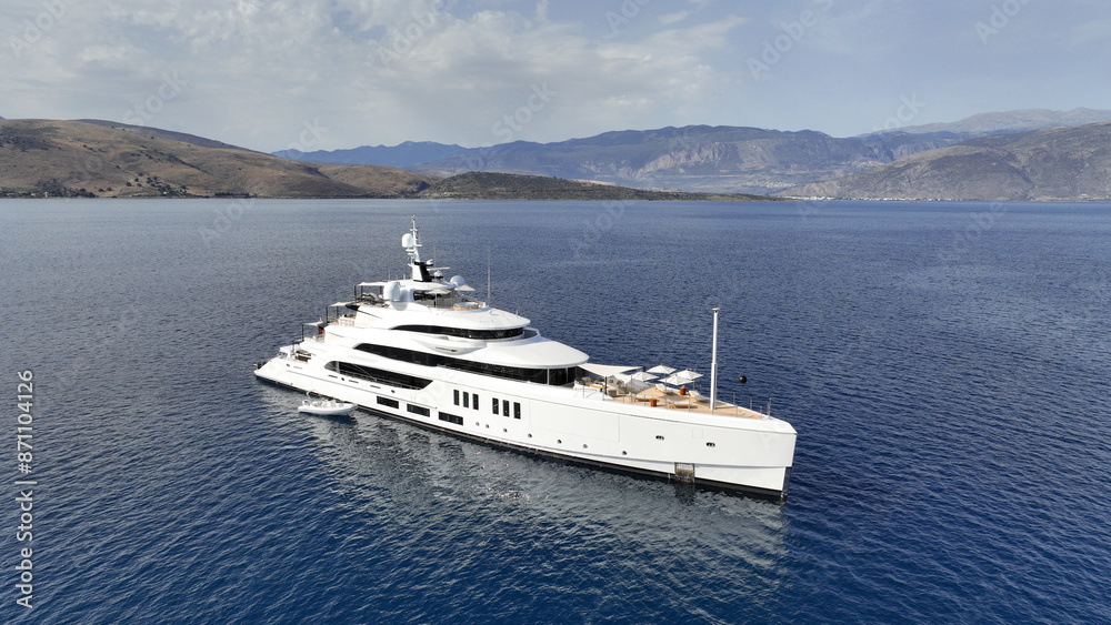 Aerial drone top down photo of luxury yacht nose with wooden deck anchored in paradise exotic deep blue sea island bay