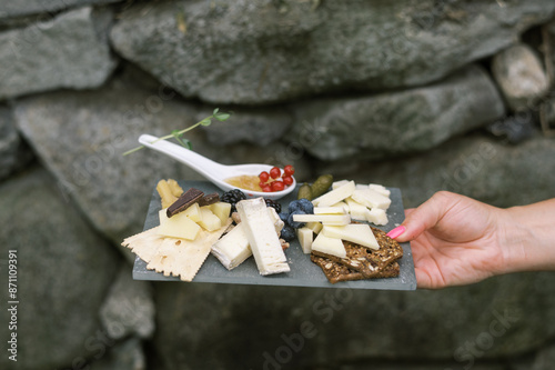 close up of cheese platter with berries, chocolate, crackers and honey