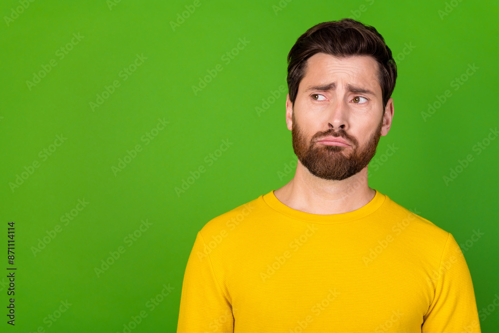 Photo of offended man with stylish beard dressed yellow shirt look at promo empty space isolated on vibrant green color background Photo of offended man with stylish beard dressed yellow shirt look at promo empty space isolated on vibrant green color background