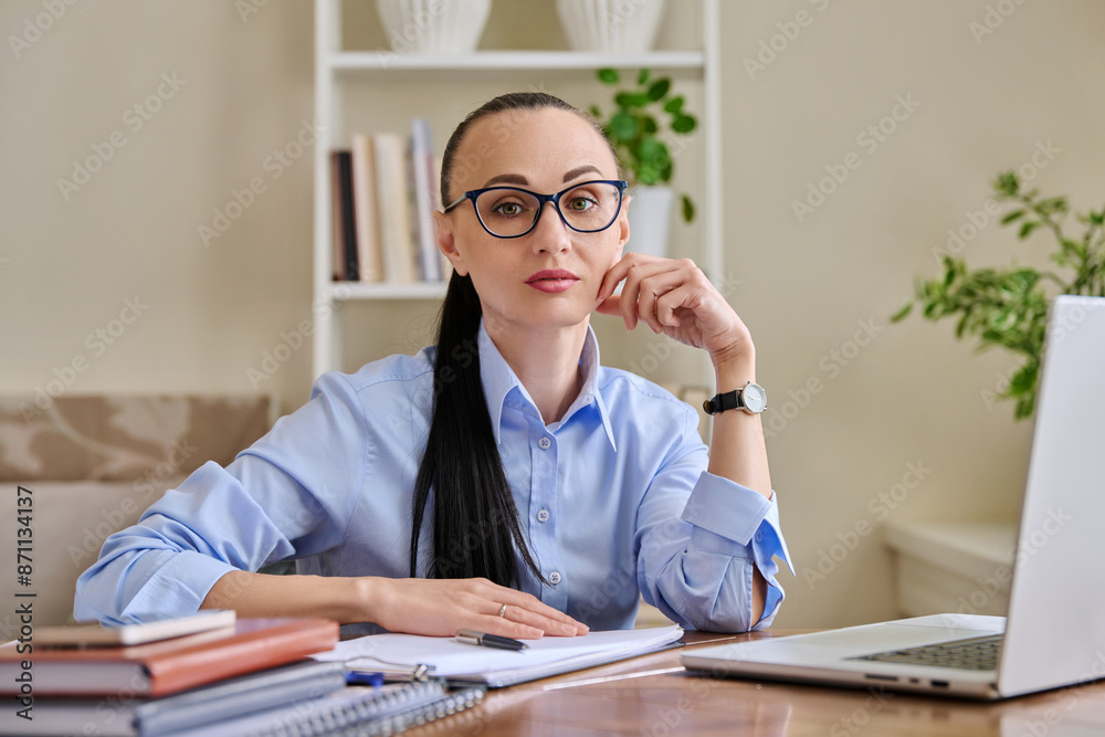 Portrait of business woman sitting at workplace desk with laptop computer Portrait of business woman sitting at workplace desk with laptop computer