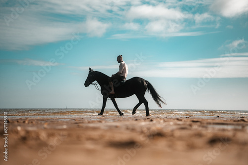 Horse riding on a beach, equestrian man riding on a horse