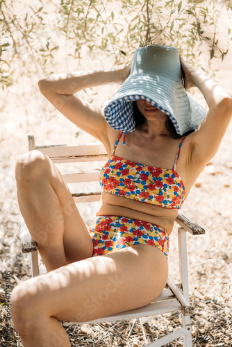 Woman adjusting sun hat

 photo