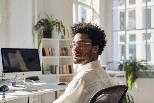 Young professional working remotely on laptop in a bright home office with indoor plants and natural light. AIG58 photo