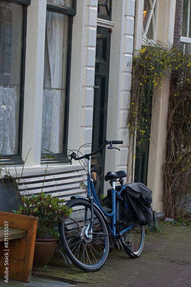 Cycles, bicycles and bikes parked on the road and against the wall on the bridge over the canal in Amsterdam city. Picturesque sunny town landscape in the Netherlands with a view of river Amstel. Cycles, bicycles and bikes parked on the road and against the wall on the bridge over the canal in Amsterdam city. Picturesque sunny town landscape in the Netherlands with a view of river Amstel.