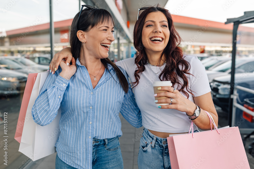 Happy girls hugging and carrying shopping bags at shopping center. Happy girls hugging and carrying shopping bags at shopping center.