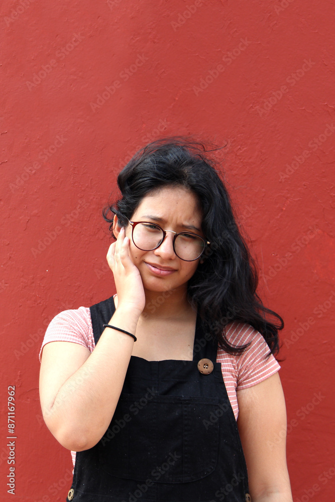 Young 17-year-old Latin woman suffers from ear pain due to acute or chronic infection due to the use of hearing aids Young 17-year-old Latin woman suffers from ear pain due to acute or chronic infection due to the use of hearing aids