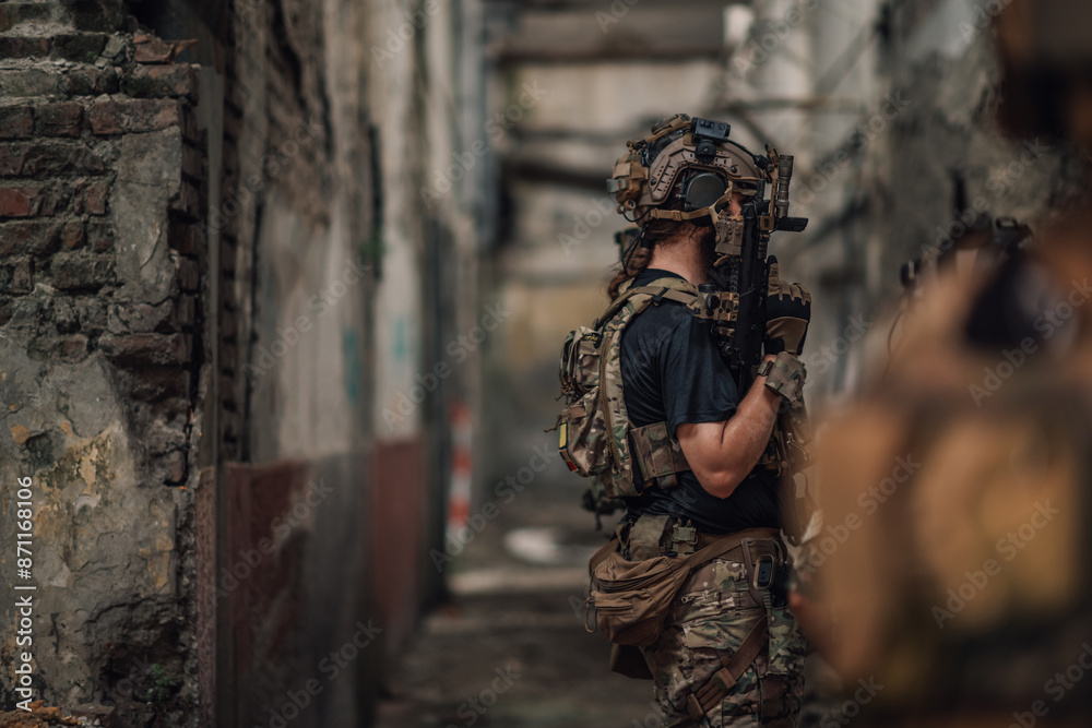 Fototapeta premium Side view of soldiers on a mission in action at abandoned building.