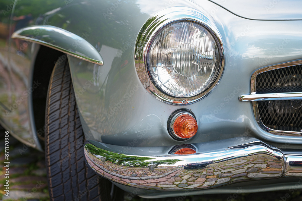 Round headlight and turn signals on a beautiful silver-gray vintage car, concept for travel, repair, sale or transportation, selected focus Round headlight and turn signals on a beautiful silver-gray vintage car, concept for travel, repair, sale or transportation, selected focus