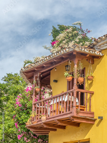 Photography Beautiful yellow buildings with colorful flowers and bougainvillea in colonial area of Cuba