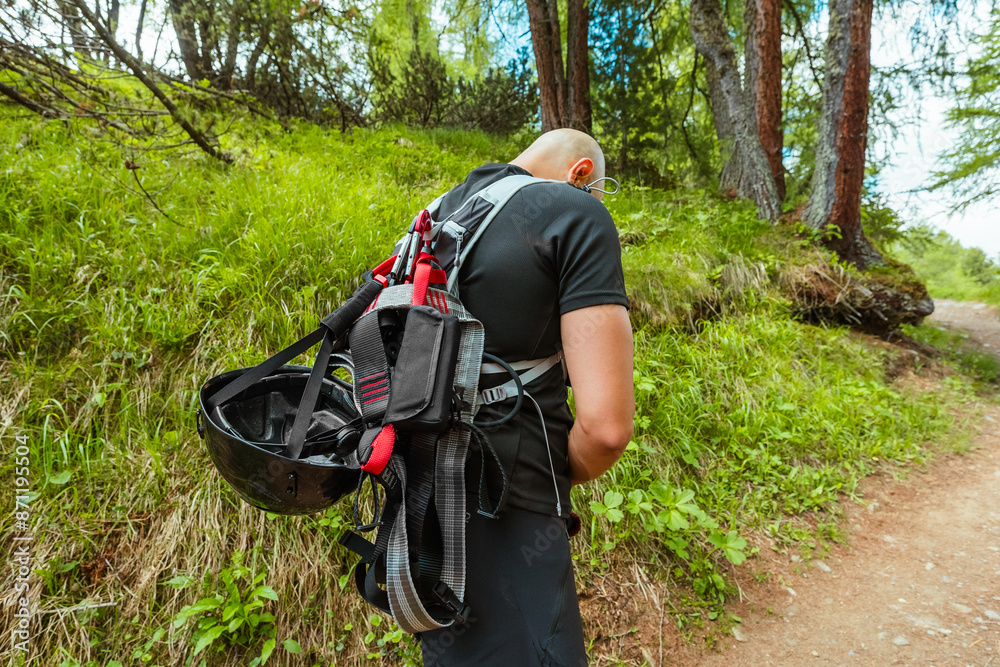 Climber with Climbing Equipment Hiking up the Mountain Trail Climber with Climbing Equipment Hiking up the Mountain Trail