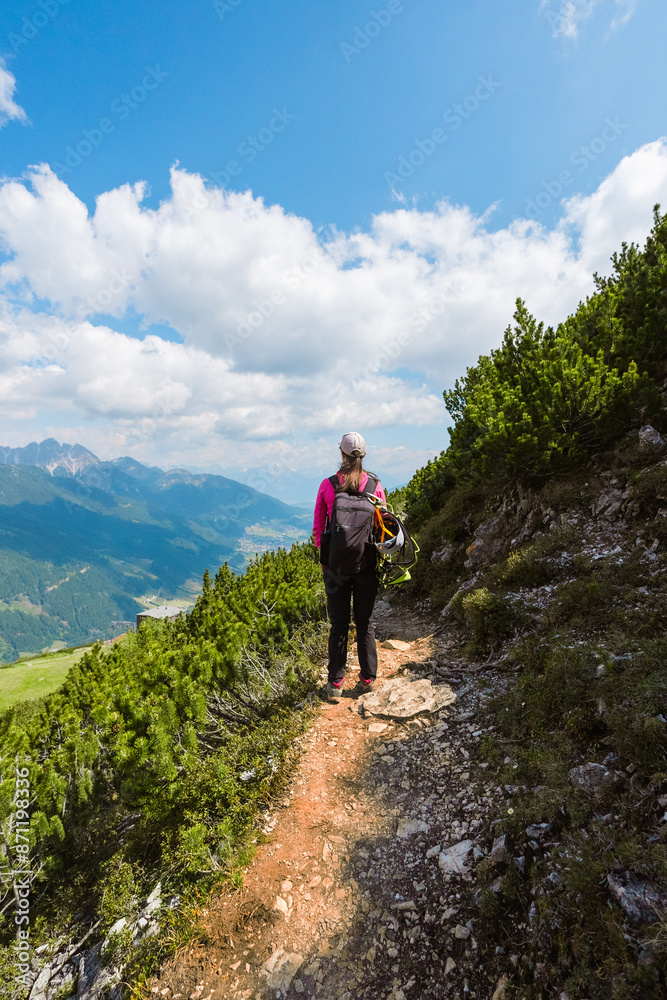 Woman Climber Standing on a High Altitude Stony Alpine Hiking Trail in the Mountains Woman Climber Standing on a High Altitude Stony Alpine Hiking Trail in the Mountains