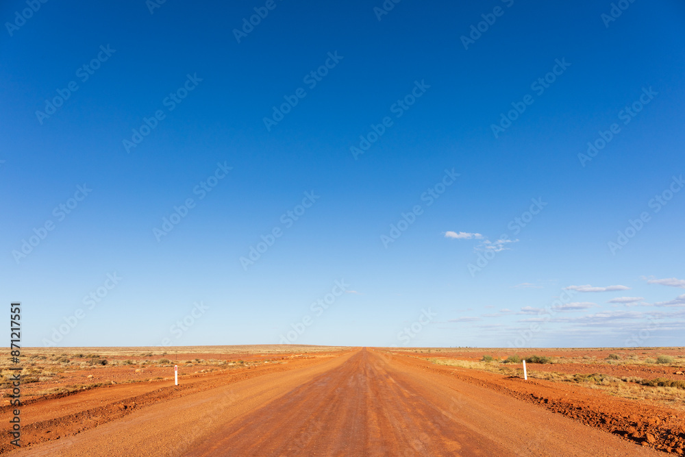 Remote red dirt road. Outback Australia. Blue sky with copy space. Remote red dirt road. Outback Australia. Blue sky with copy space.