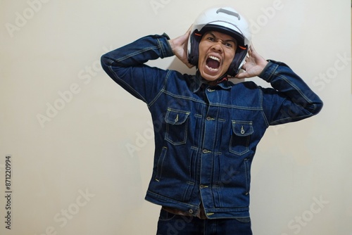 A Southeast Asian man wearing helmt and scream isolated over cream background, driver taxi online. stock photo.