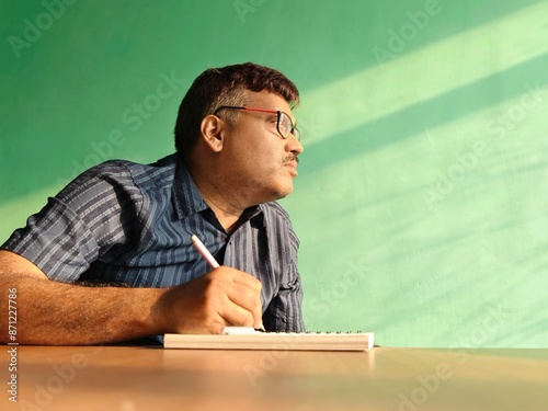 Middle aged Indian man wring inside a house