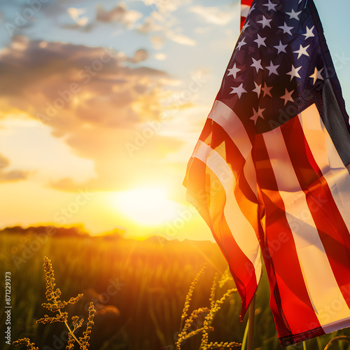 American flag waving in the wind with a golden field in the background at sunset