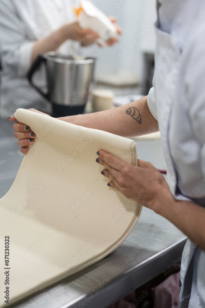 Professional chef rolling dough in kitchen Professional chef rolling dough in kitchen