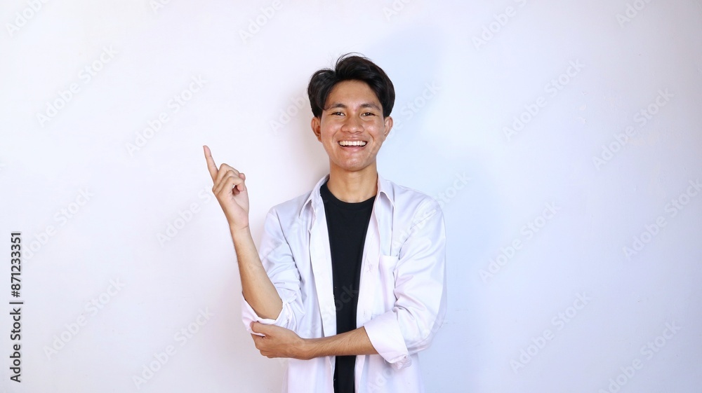 Excited young Asian man gesturing pointing upwards Excited young Asian man gesturing pointing upwards