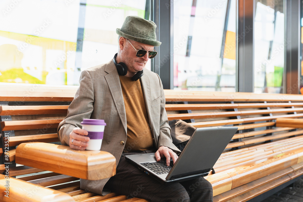 Middle age tourist man working on laptop in train station Middle age tourist man working on laptop in train station