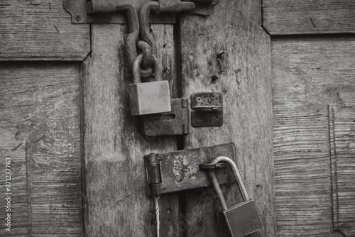 A wooden door with a lock and a padlock
