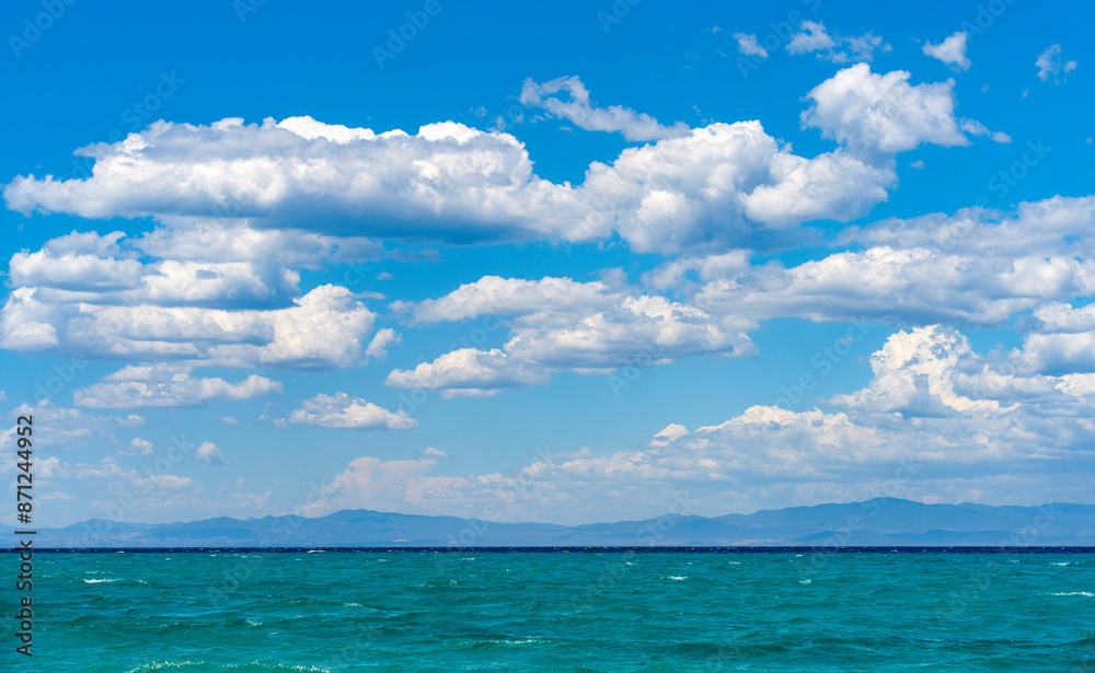 Beautiful blue color of the sea with white puffy clouds in backgrounds Beautiful blue color of the sea with white puffy clouds in backgrounds