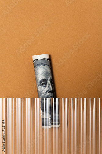 US Dollar banknote roll on brown background under corrugated glass photo