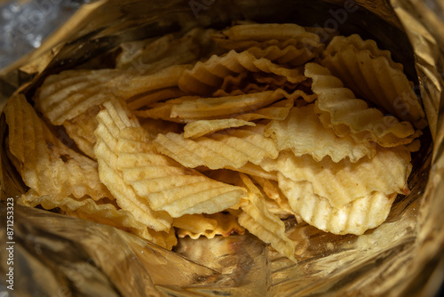 Golden, ridged potato chips - inside a foil bag - close-up view. Taken in Toronto, Canada. photo