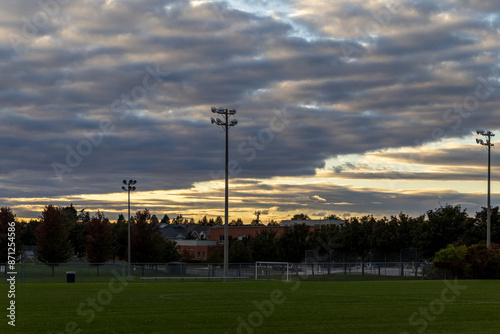 Sunset over soccer field - dramatic clouds - silhouette of stadium lights - trees behind. Taken in Toronto, Canada. photo