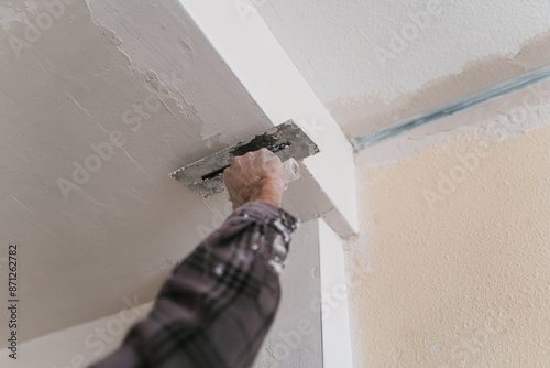 Crop man plastering wall with putty paint photo