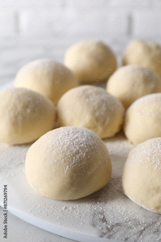 Many raw dough balls with flour on table Many raw dough balls with flour on table