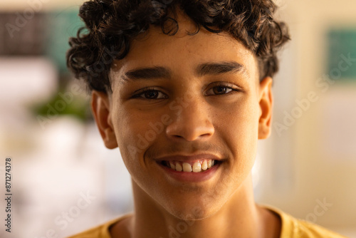 Smiling teenage boy in high school, looking at camera with confidence