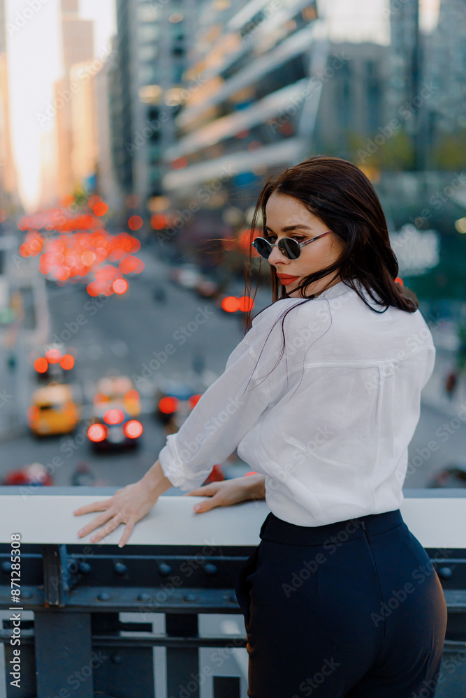 Woman in city at sunset, surrounded by urban lights and highrises Woman in city at sunset, surrounded by urban lights and highrises