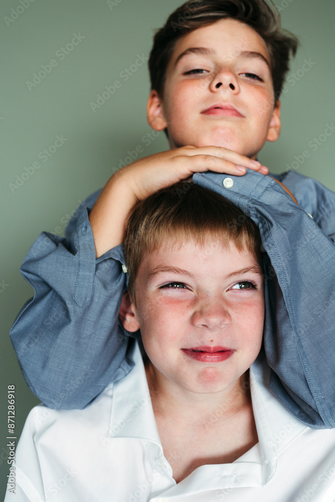 Two Boys Posing Indoors in Casual Shirts, Daytime Two Boys Posing Indoors in Casual Shirts, Daytime