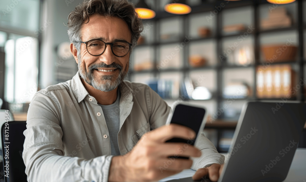 Happy Middle Aged Hispanic Businessman Using Mobile Phone at Desk in Modern Office Smiling Mature CEO with Glasses Working on Laptop Bright Natural Light Happy Middle Aged Hispanic Businessman Using Mobile Phone at Desk in Modern Office Smiling Mature CEO with Glasses Working on Laptop Bright Natural Light