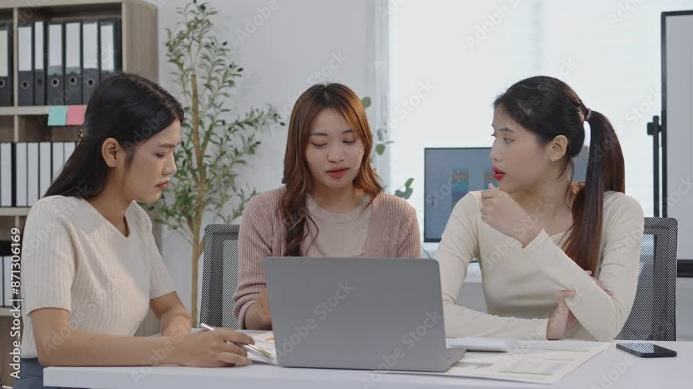 Three women professionals collaborating on a project in a modern office. Slow-motion footage captures their teamwork, discussion, and interaction with a laptop and documents Three women professionals collaborating on a project in a modern office. Slow-motion footage captures their teamwork, discussion, and interaction with a laptop and documents