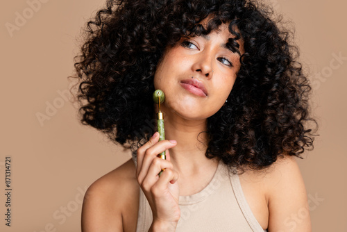 woman using jade roller on her face