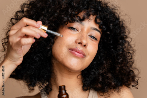 woman applying facial serum photo