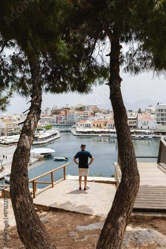 Tourist looking down on the village of Agios Nikolaos photo