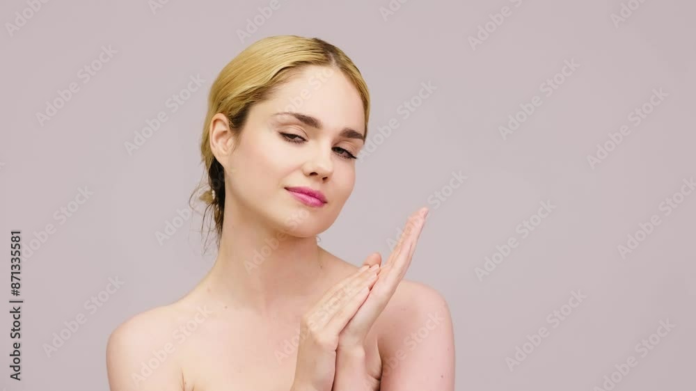 A young woman with clean and youthful skin applies moisturizer to her face. Natural cosmetics, care and spa concept. A young woman with clean and youthful skin applies moisturizer to her face. Natural cosmetics, care and spa concept.