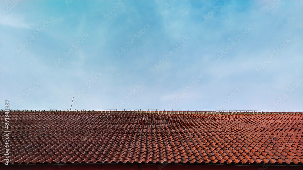 roof tiles of a building with a bright blue sky during the day roof tiles of a building with a bright blue sky during the day