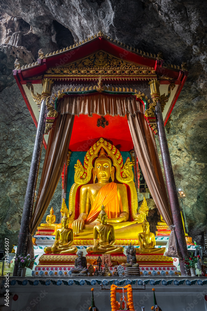 Fototapeta premium The large Buddha gold statue inside the cave at Wat Ban Tham, Kanchanaburi, Thailand