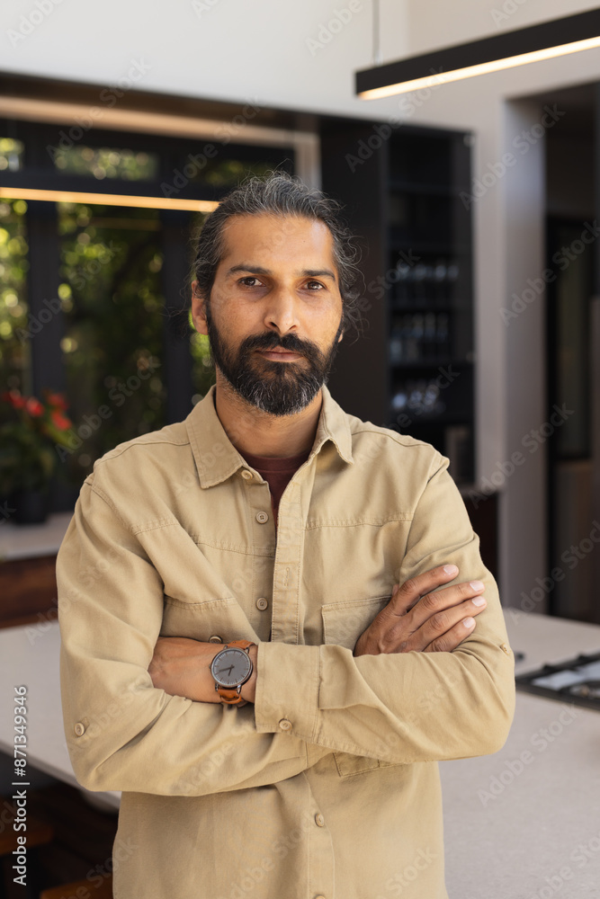 Confident man with crossed arms standing in modern kitchen at home Confident man with crossed arms standing in modern kitchen at home