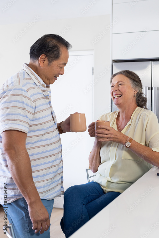 Senior couple enjoying coffee together, smiling and chatting in kitchen Senior couple enjoying coffee together, smiling and chatting in kitchen