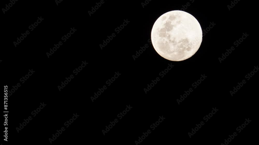 A quick shot of a shining full moon on the upper right side of the frame. A quick shot of a shining full moon on the upper right side of the frame.