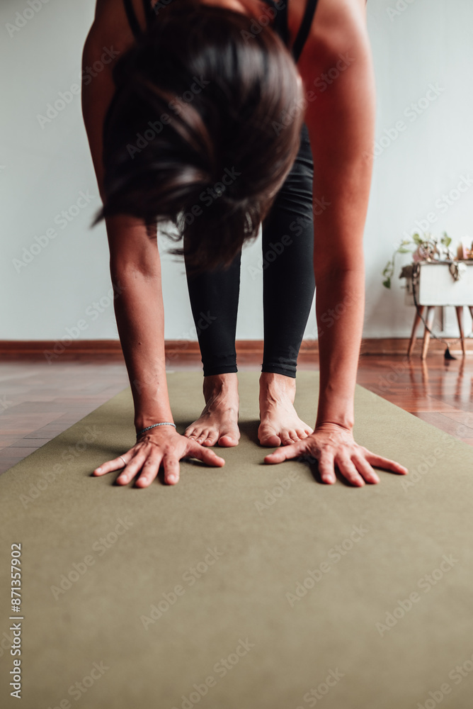 Close-up of a woman practicing yoga standing bending forward. Close-up of a woman practicing yoga standing bending forward.