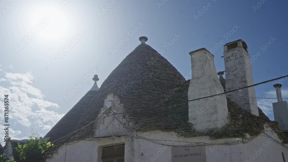 Traditional trullo house with conical roofs under a bright sunny sky in alberobello, puglia, italy, showcasing local architecture and cultural heritage. Traditional trullo house with conical roofs under a bright sunny sky in alberobello, puglia, italy, showcasing local architecture and cultural heritage.