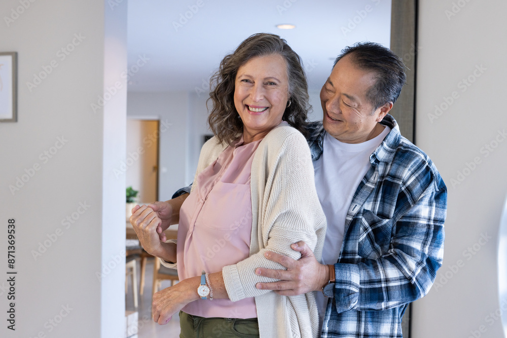 Senior couple hugging and smiling, enjoying quality time together at home