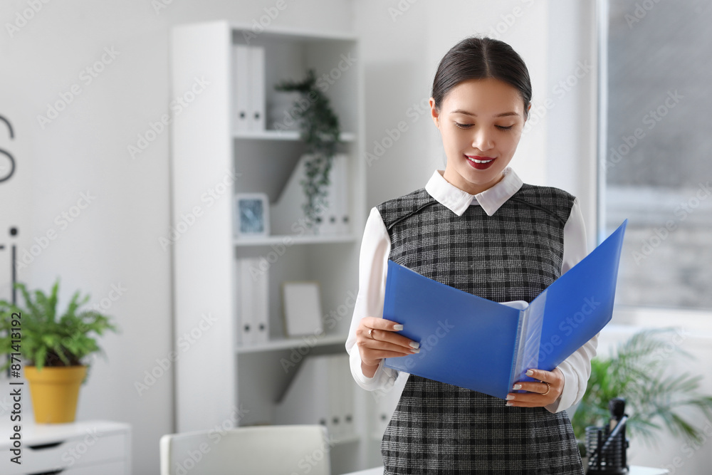 Portrait of Asian businesswoman with folder in office Portrait of Asian businesswoman with folder in office