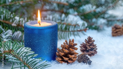Christmas Scene with Blue Elements Lit Candle Evergreens and Pine Cones on Snowy Backdrop