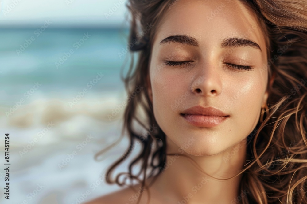Obraz premium A calm young woman stands on a sandy beach, breathing in the fresh air, reflecting a moment of relaxation and connection with nature.
